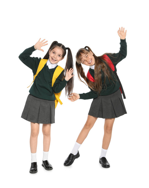 Kleine meisjes in stijlvolle school uniform op witte achtergrond - Foto, afbeelding