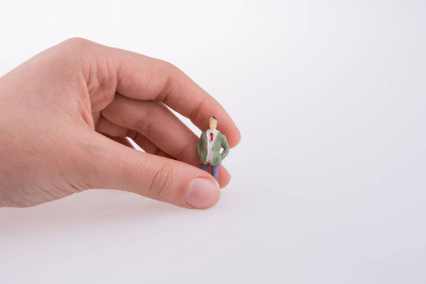 Hand holding a figure on a white background - Zdjęcie, obraz