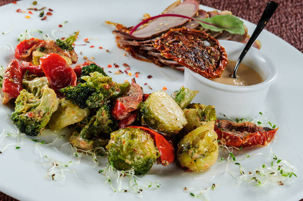 Filetes de bacalao asados rollos servidos con mijo y brócoli al vapor, zanahoria, coles de Bruselas y calabacín
 - Foto, imagen
