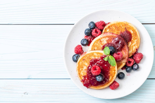 souffle pancake with fresh raspberries and blueberries - Фото, изображение