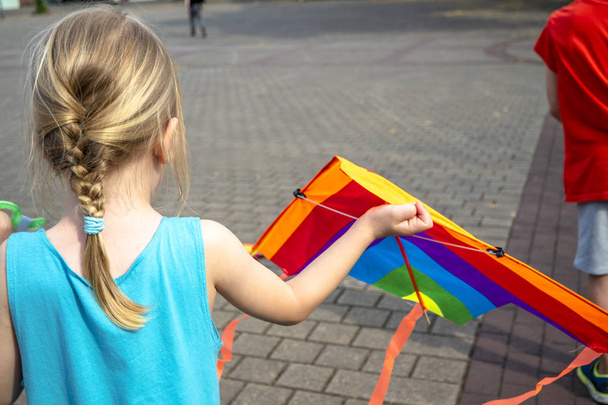 Little girl having fun flying a kite in summer - Photo, image