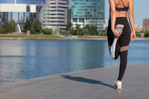 Donna attraente riscaldamento e stretching prima di fare jogging su argine
 - Foto, immagini
