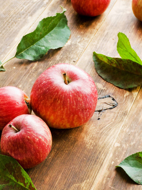 Ripe red apples with leaves on wooden background. Shallow dof. - Foto, afbeelding