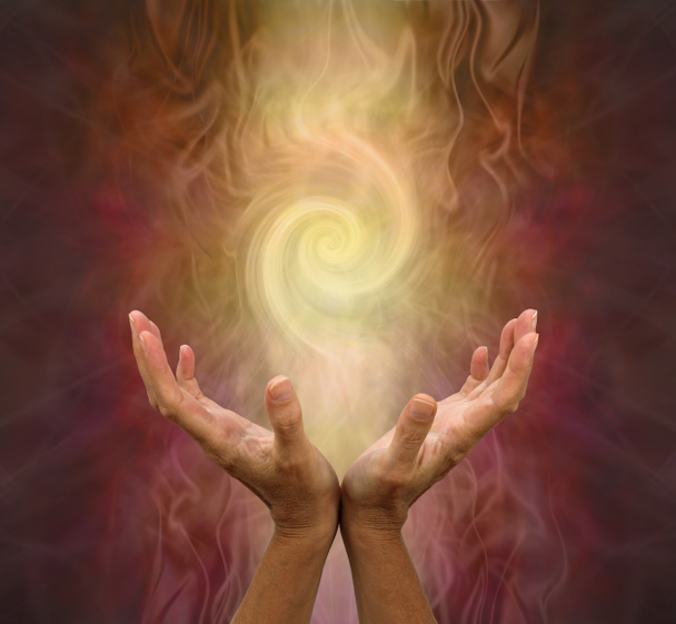 Целебная энергия Золотого Вихря - женские руки раскрыты и ладонями вверх с вихревым энергетическим образованием вверху на теплом золотисто-коричневом фоне
 - Фото, изображение