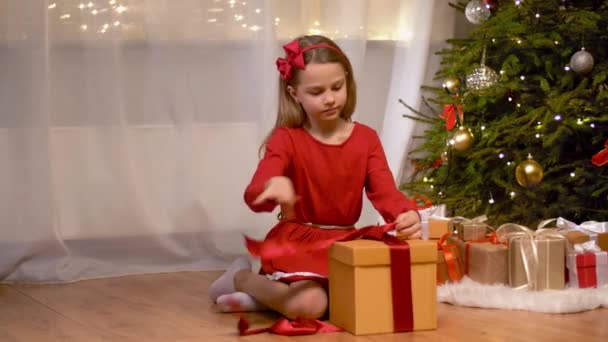 happy girl opening christmas gift at home - Πλάνα, βίντεο