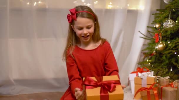 happy girl opening christmas gift at home - Materiał filmowy, wideo