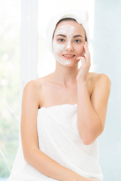 Beautiful woman having a facial cosmetic scrub treatment from professional dermatologist at wellness spa. Anti-aging, facial skin care and luxury lifestyle concept. - Фото, зображення