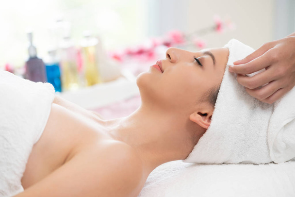 Giovane donna rilassata sdraiata sul letto spa preparata per il trattamento del viso e il massaggio in resort spa di lusso. Benessere, sollievo dallo stress e ringiovanimento. - Foto, immagini