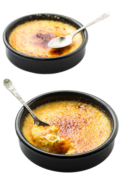 Four creme brulee in ramequins with spoons over white background - Photo, Image