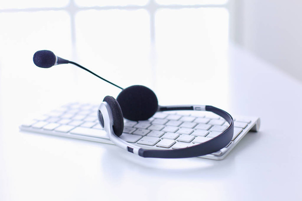 Puhelinkeskus ja asiakaspalvelun neuvonta. VOIP-kuulokkeet kannettavan tietokoneen näppäimistöllä
 - Valokuva, kuva