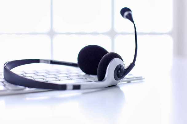 Call center en customer service helpdesk. VoIP hoofdtelefoon op laptop computertoetsenbord - Foto, afbeelding