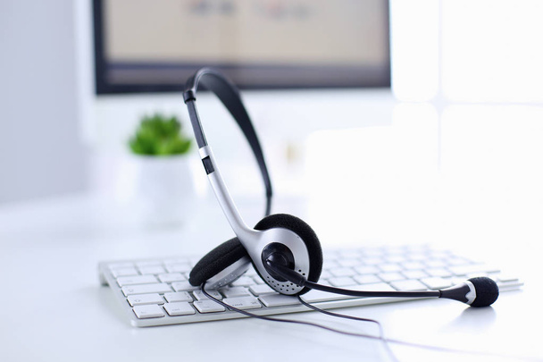 Call center en customer service helpdesk. VoIP hoofdtelefoon op laptop computertoetsenbord - Foto, afbeelding