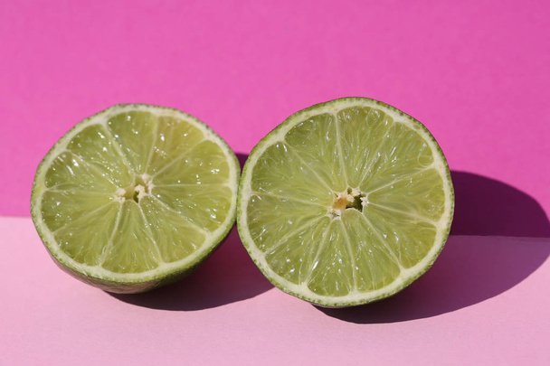 Limes cut open, pink background - Photo, image