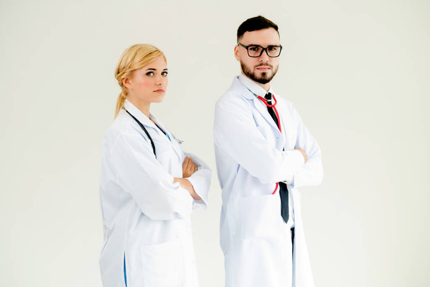 Médecins confiants debout sur fond blanc avec les bras croisés. Concept d'équipe médicale professionnelle
. - Photo, image