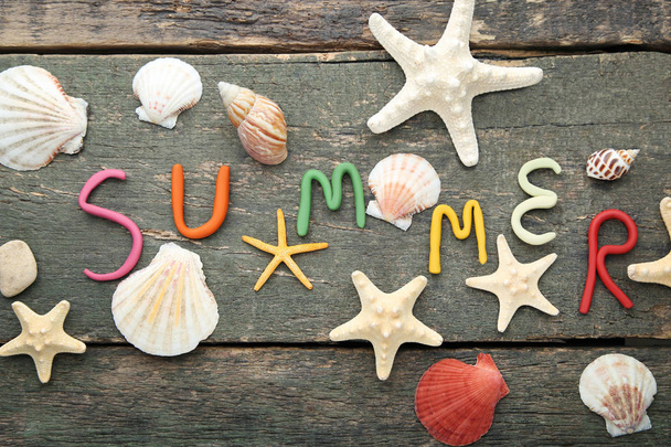 Надпись Summer by plasticine with seashells on grey wooden table
 - Фото, изображение