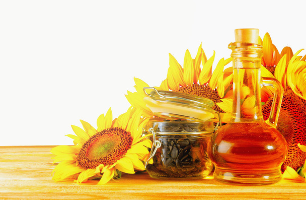 Sunflower oil, seeds and sunflowers on the table - Photo, Image