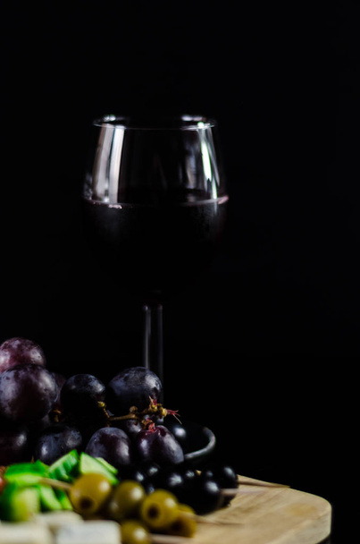 Κόκκινο κρασί και το σύνολο των τυριών σε μια ξύλινη σανίδα, νόστιμο σνακ, υγιεινά και αποκλειστική τροφή - Φωτογραφία, εικόνα