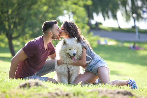 Schönes junges Paar, das Zeit mit seinem Hund im Park hat. - Foto, Bild