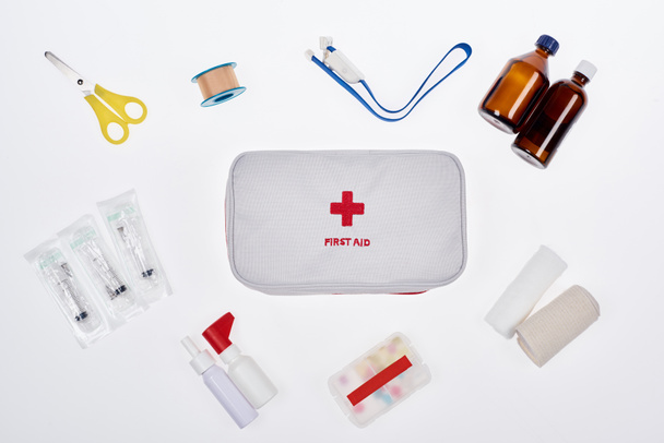 tendido plano con botiquín automotriz de primeros auxilios con varios medicamentos aislados en blanco
 - Foto, Imagen