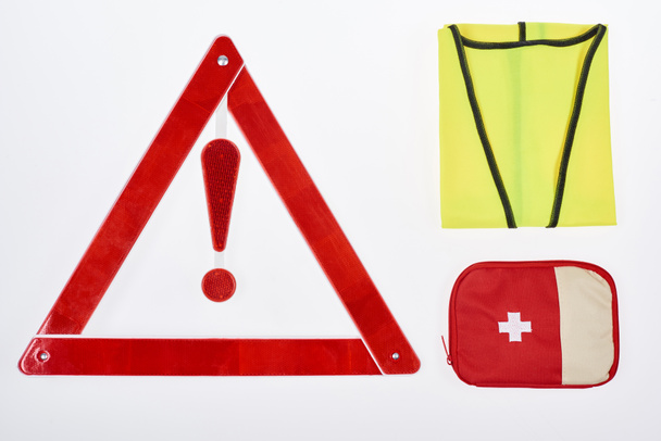 plano con triángulo de advertencia, botiquín de primeros auxilios y chaleco reflectante aislado en blanco
 - Foto, Imagen