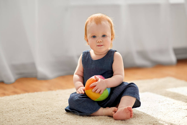 lovely redhead baby girl with toy ball at home - Photo, image