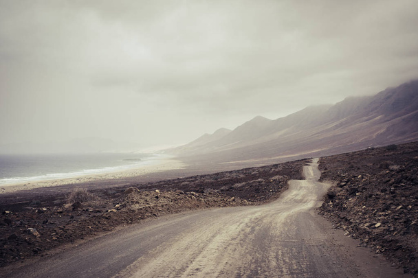 ground long way road along wild beach and mountains - Foto, imagen