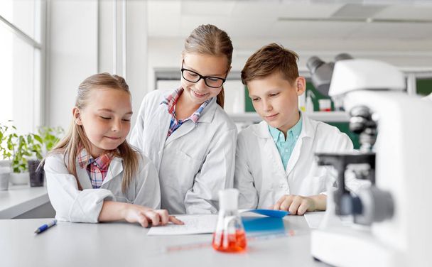 kids studying chemistry at school laboratory - Photo, Image