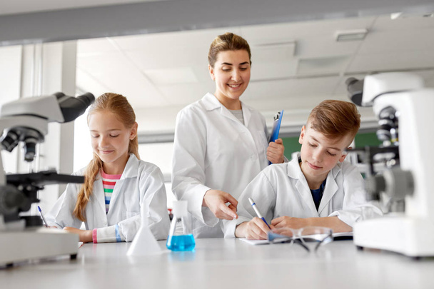 teacher and students studying chemistry at school - Photo, image