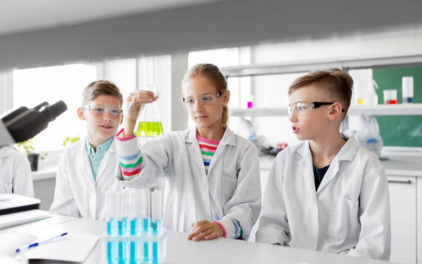 kinderen met reageerbuisjes studie chemie op school - Foto, afbeelding