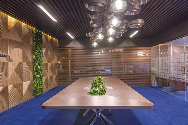 Interior of a modern office. Furniture in the office of the company. Large meeting table with live plants. Live plants in the wall of the negotiation room. - 写真・画像