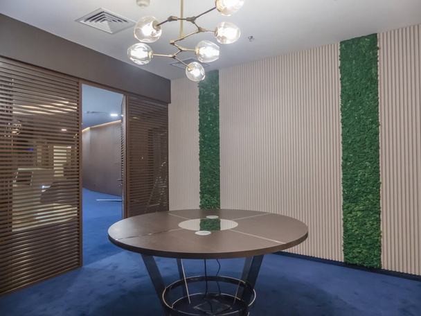 Interior of a modern office. Furniture in the office of the company. Large meeting table. Live plants in the wall of the negotiation room. - Foto, Imagen