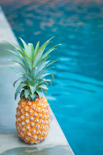 Fresh yellow pineapple tropic fruit summer refreshment near pool - Photo, image