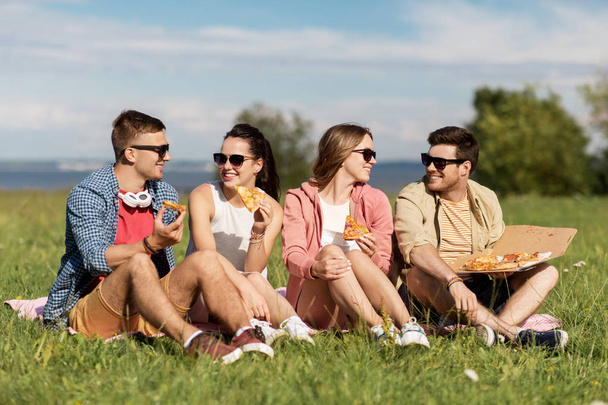 friends eating pizza at picnic in summer park - Zdjęcie, obraz