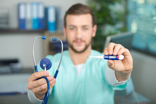 male doctor holding thermometer and stethoscope - 写真・画像