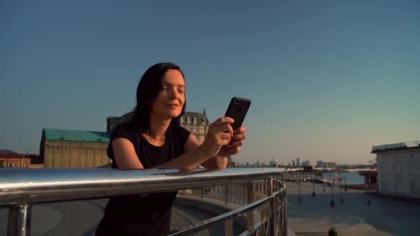 χαρούμενη γυναίκα πληκτρολογώντας ένα μήνυμα για το ηλιοβασίλεμα - Πλάνα, βίντεο