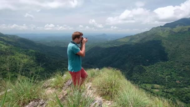 Fotógrafo de aventura con tomas de cámara mientras está de pie en el pico mini Adams en Sri Lanka. Gran vista desde la parte superior
. - Metraje, vídeo