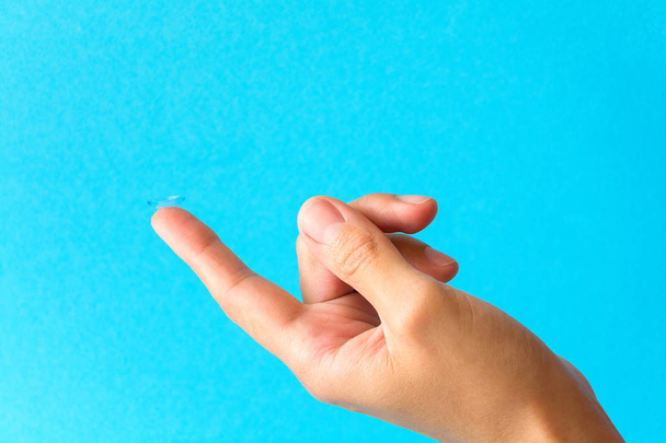 Contact lens on finger on blue background - Foto, immagini