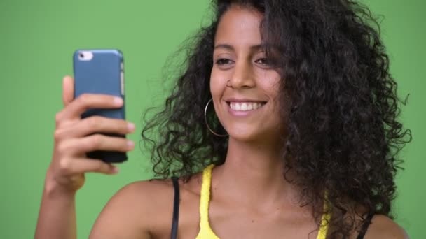 Young beautiful Hispanic woman using phone - 映像、動画