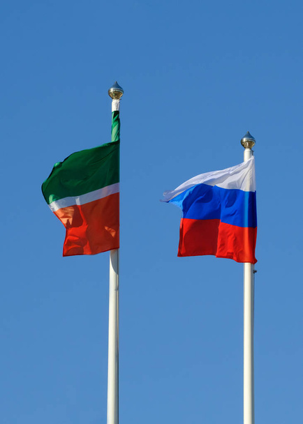 Bandeira da República do Tartaristão e bandeira da Federação Russa contra o céu azul
 - Foto, Imagem