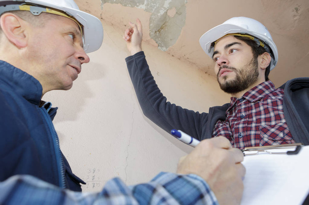 builders inspecting roof damage - Foto, imagen