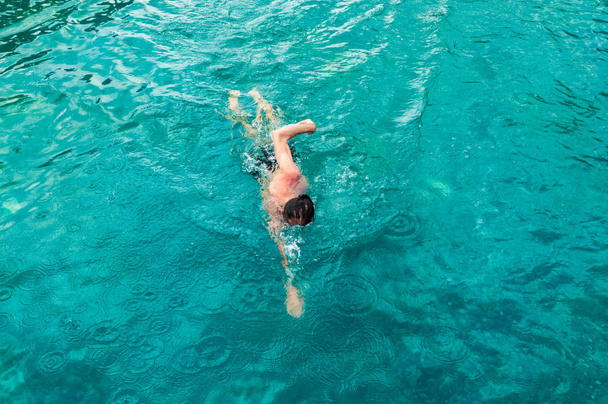 Κάτοψη του ένας νεαρός άνδρας Καυκάσιος κολύμπι σέρνεται μπροστά στην πισίνα - Φωτογραφία, εικόνα