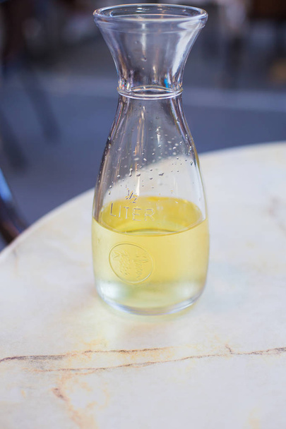 Vinho branco em uma garrafa de litro em uma mesa em um café - Foto, Imagem