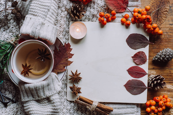Stylish Flat lay view of autumn leaves and tartan textured sweater on wooden background with cup of tea .  Autumn or Winter concept.  - Fotoğraf, Görsel