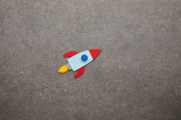 kleurrijke handgemaakte raket op grijze achtergrond - Foto, afbeelding
