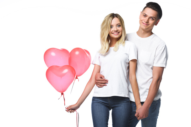 pareja de pie con manojo de globos en forma de corazón aislados en blanco
 - Foto, imagen