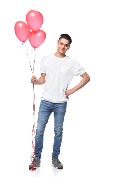 homem bonito de pé com feixe de balões em forma de coração isolado em branco
 - Foto, Imagem