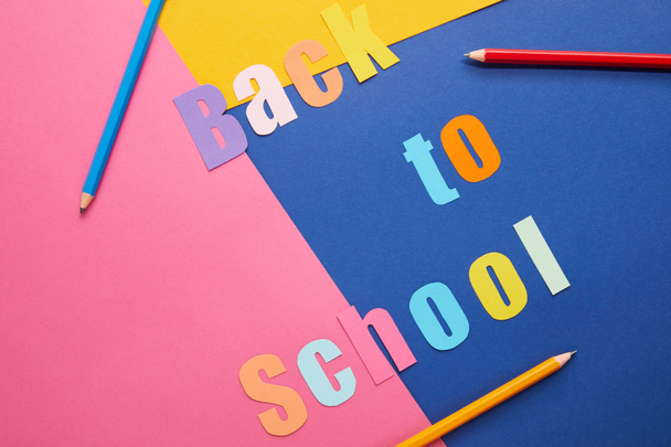 colorful back to school lettering with pencils on paper background - Foto, Imagem