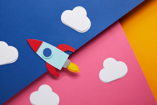 top view of clouds and rocket on colorful paper background - 写真・画像