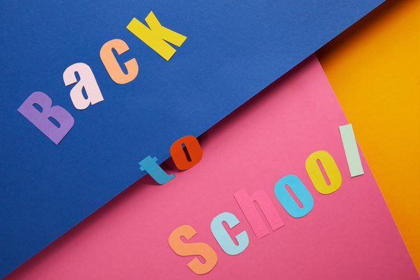 flat lay with "back to school" lettering on colorful paper background - Foto, Bild