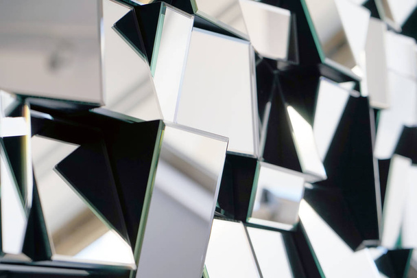 Spiegel mit Vierecken in Wand, Dekoration und Reflexion. abstrakter Glashintergrund. polygonale Oberfläche. Nahaufnahme. Textur. - Foto, Bild